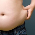 Boy (6-8) pinching fat