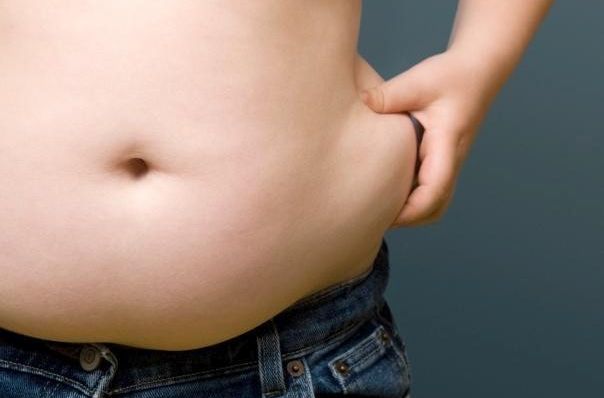 Boy (6-8) pinching fat