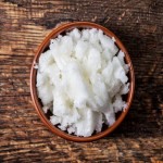 bowl of coconut oil on wooden table, top view